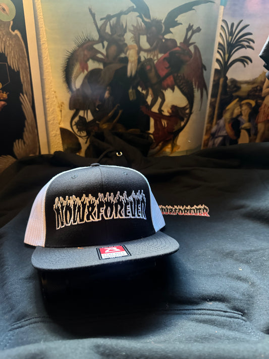Now & Forever Industries flame logo trucker cap — black wool-blend front panel with the flame logo embroidered across it, flat bill, high crown, snapback closure
